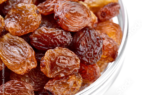 bowl of raisins on a white background. Dried grapes.