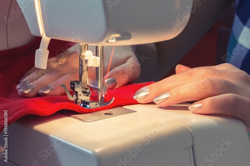 Woman sews red christmas sock