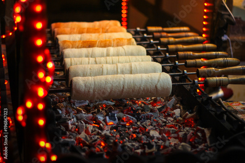 Kurtos kalacs (Chimney Cakes) baking on roll spinning over hot coals at a Christmas market stand