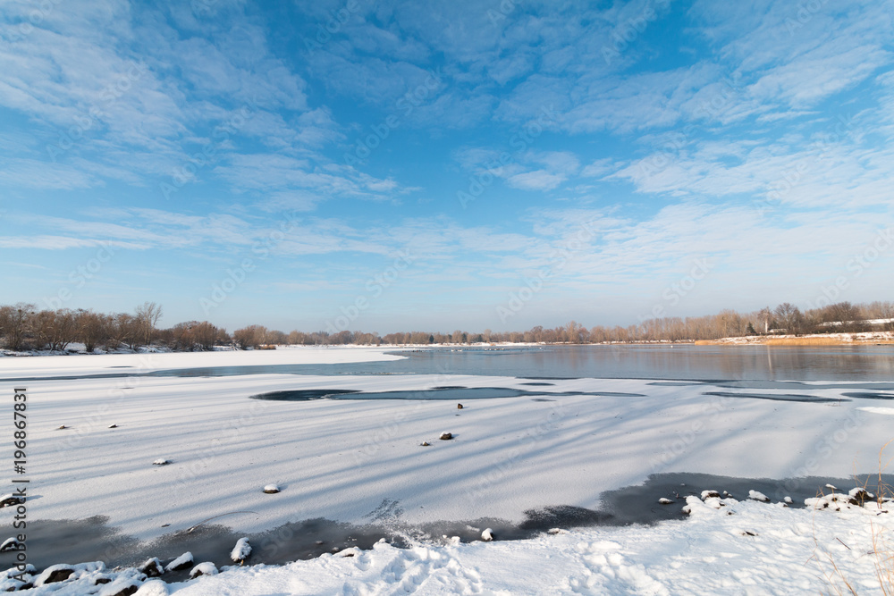 gefrorener See oder Fluss im Winter mit Eis und Schnee bei sonnigem Wetter und blauem Himmel gefrorener See oder Fluss im Winter mit Eis und Schnee bei sonnigem Wetter und blauem Himmel