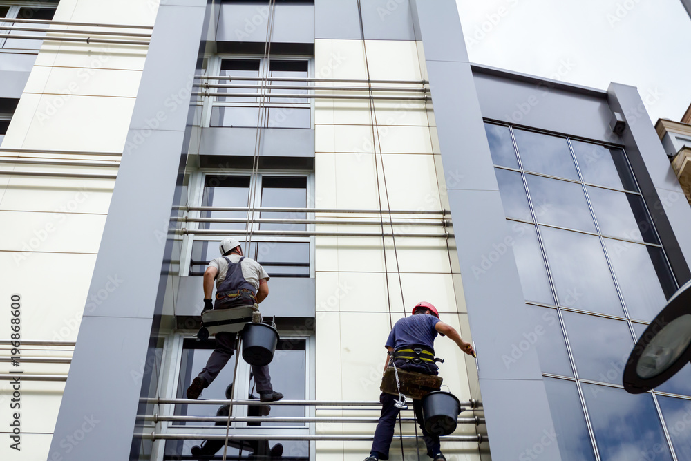 Team of industrial climbers at work, they are washing building facade