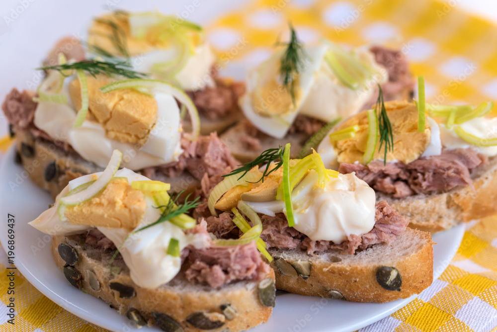 Bruschetta, snack sandwiches with tuna, egg and mayonnaise decorated by dill.