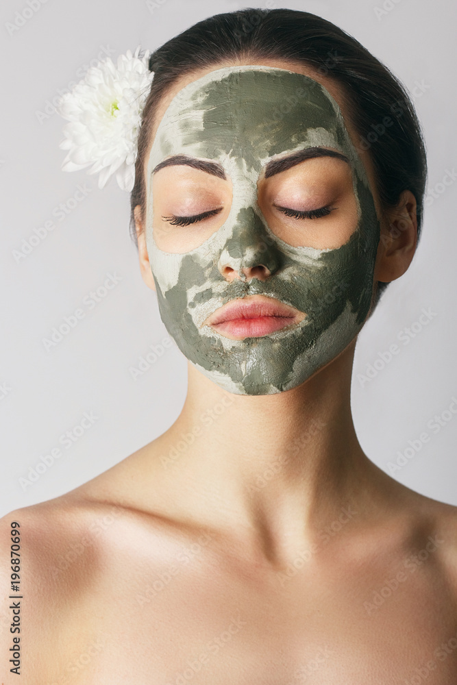 Spa Woman applying Facial clay Mask. Beauty Treatments. Close-up portrait of beautiful girl applying facial mask.Cosmetology. Body care girl's.Skincare.