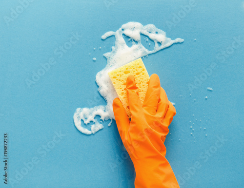 Fotografie Hand in glove washing glass surface with sponge and cleaning foam