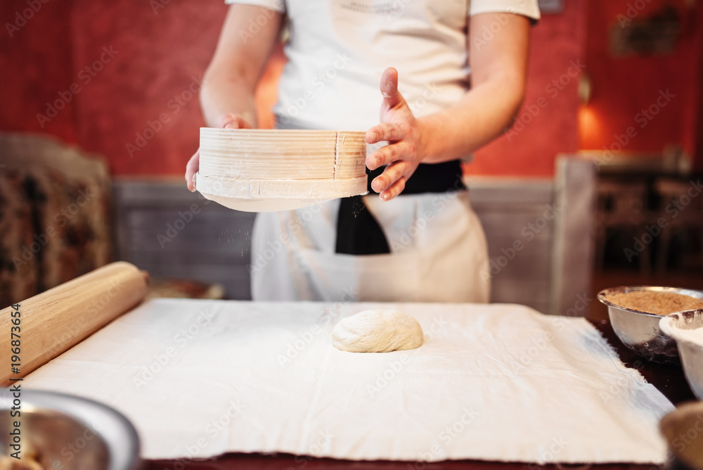 Obraz premium Male person works with dough on kitchen table