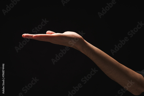 Man holding palm open isolated on black