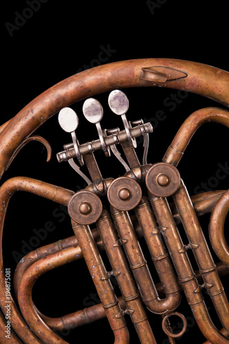 Vintage bronze pipes, valve, key mechanical elements french horn, black background. Good pattern, prompt music instrument. photo