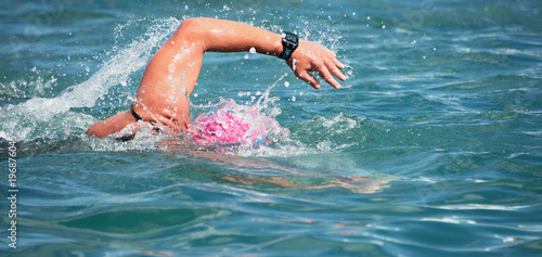 Swimmer swimming crawl in blue sea,training for triathlon