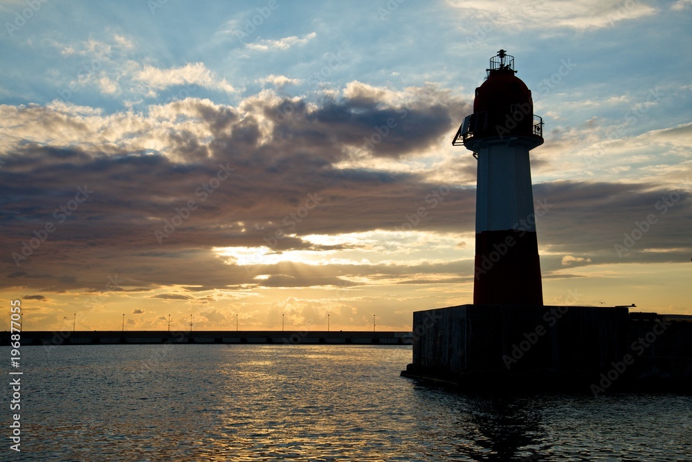 Lighthouse on the sunset sky background.