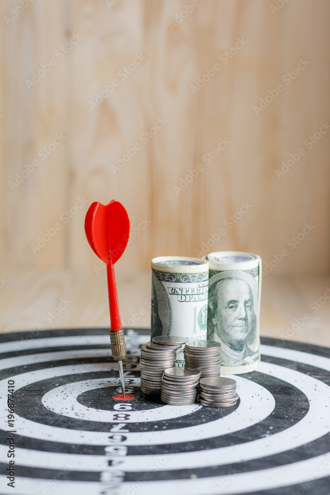 Red dart arrow hit the center target of dartboard and money coin metaphor marketing or saving money concept Red dart arrow hit the center target of dartboard and money coin metaphor marketing or saving money concept
