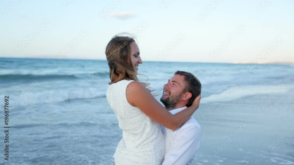 A guy and a girl are having fun on the beach. Bride and groom by the sea on their wedding day. Wedding photosession. Greece A guy and a girl are having fun on the beach. Bride and groom by the sea on their wedding day. Wedding photosession. Greece