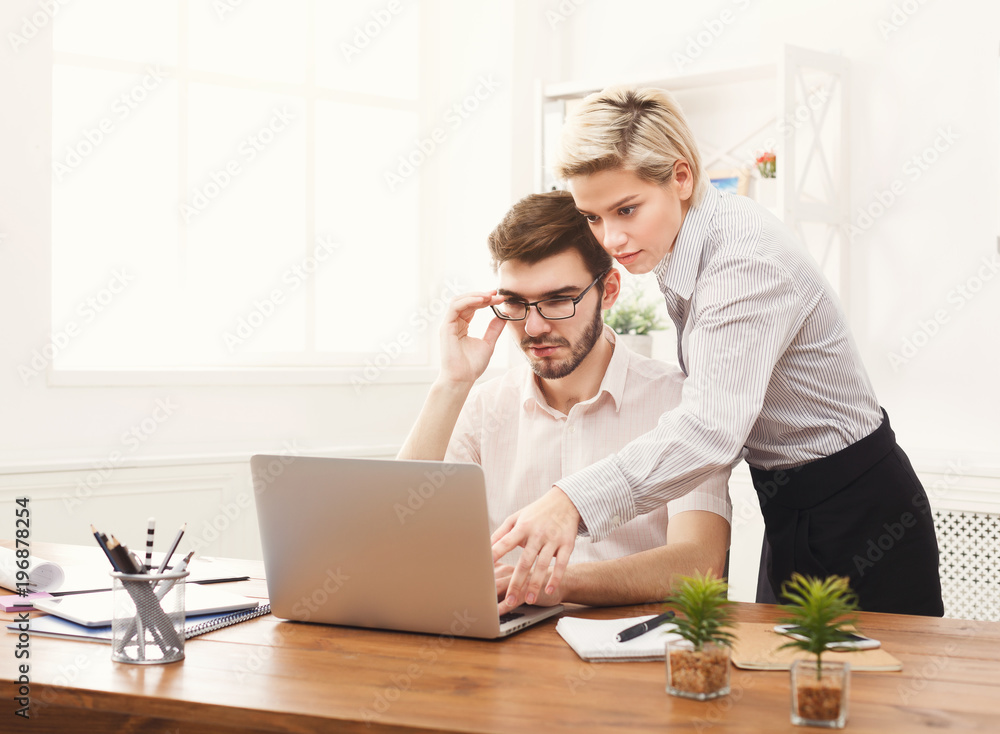 Couple of young colleagues working at modern office Couple of young colleagues working at modern office