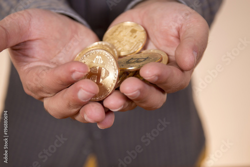 hand holding a bunch of bitcoins