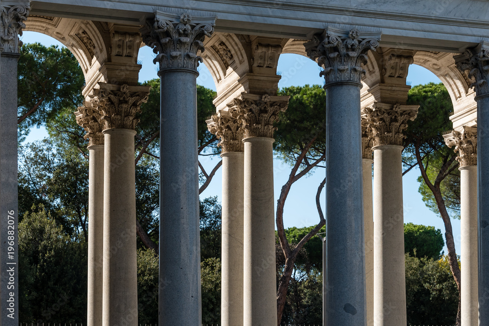 Marble columns in the St. Paul’s Cathedral, Rome, Italy. Marble columns details, plants and blue sky in background.