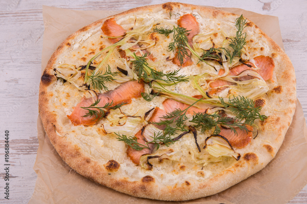 Pizza with the baked trout and onions of jalapeno, is served with greens