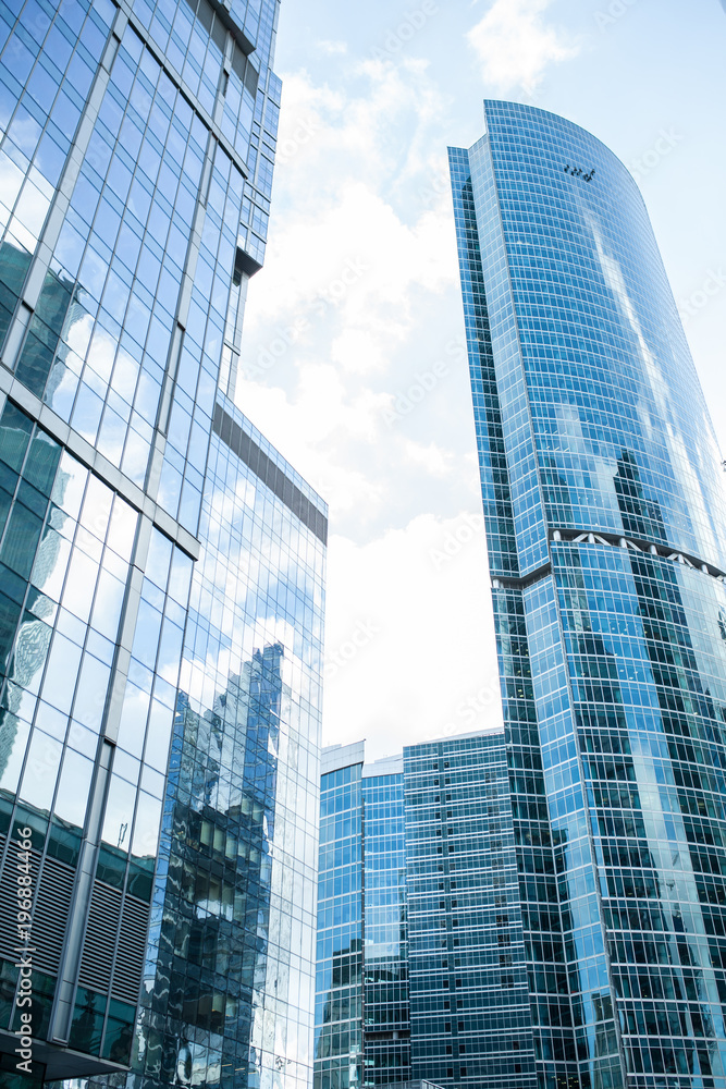 Detail blue glass building background with cloud sky