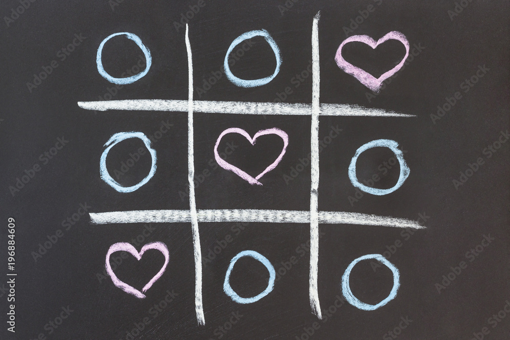 love concept. Tic tac toe game drawn by chalk on black school blackboard. love concept. Tic tac toe game drawn by chalk on black school blackboard.