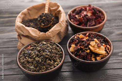 Different types of dry tea leaves on table © Pixel-Shot