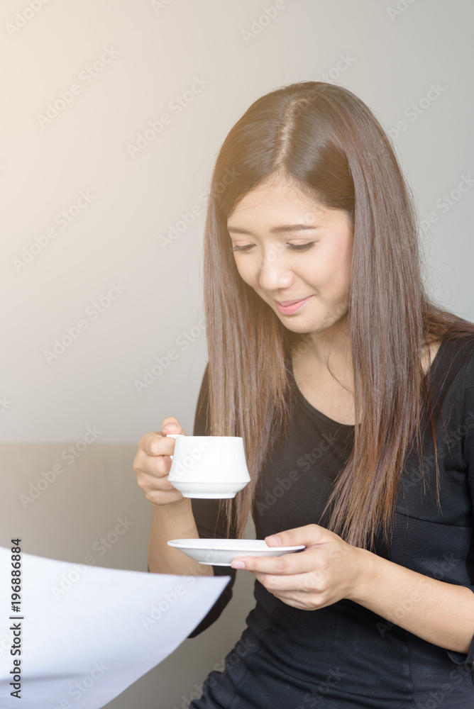 A asain businesswoman has drinking a cup of coffee with workmate together in the office. A asain businesswoman has drinking a cup of coffee with workmate together in the office.