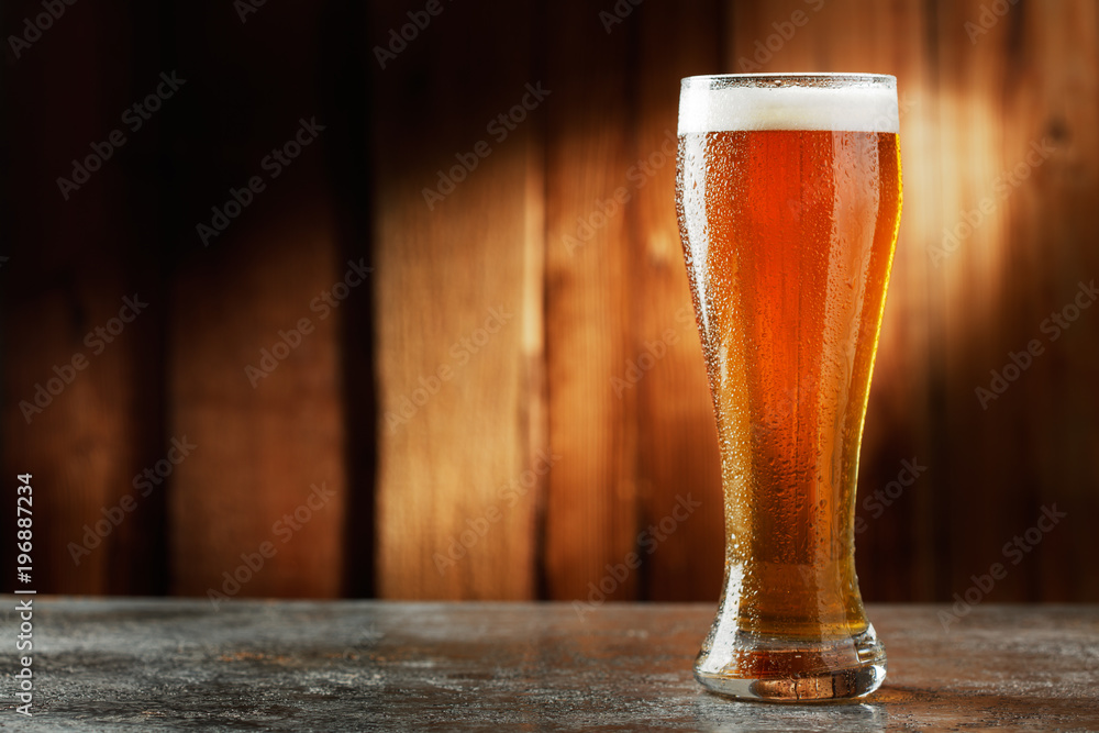 glass with beer on a wooden background