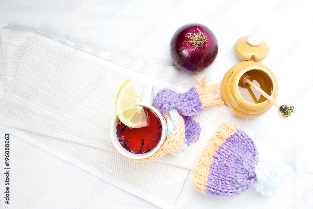 Concept of flu sick person with cap and scarf with healthy tea, fruit and vegetable Concept of flu sick person with cap and scarf with healthy tea, fruit and vegetable