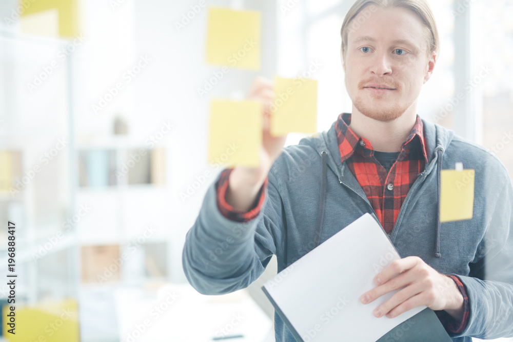 Businessman in office working on new project looking on adhesive notes Businessman in office working on new project looking on adhesive notes