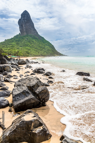 Fernando de Noronha, Brazil. Beach of Conceicao. Conceiçao with rocks in the foreground. photo