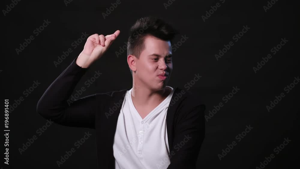 An attractive young man dancing against a black background. Medium Shot An attractive young man dancing against a black background. Medium Shot