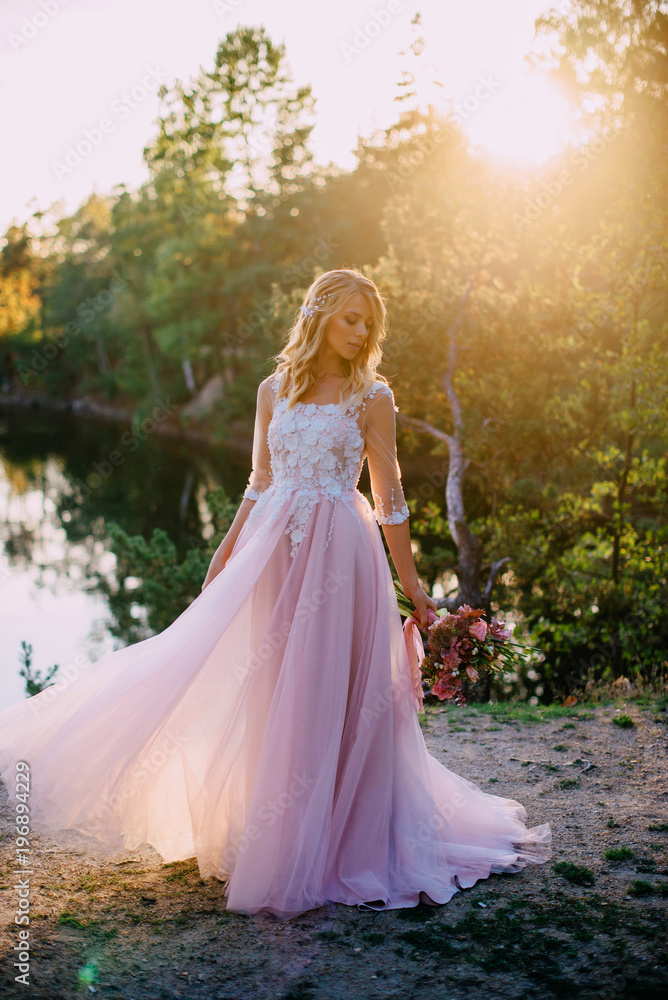 portrait of a young beautiful bride in the sun on a nature background