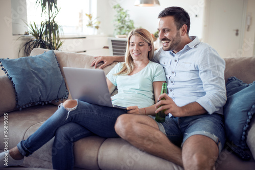 Couple on sofa using a laptop