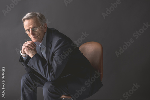 Bild auf Leinwand Portrait of thoughtful mature male leaning on arm while looking at camera