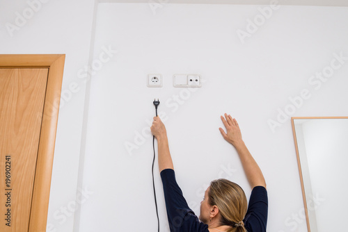 The woman can not reach out the electrical outlet