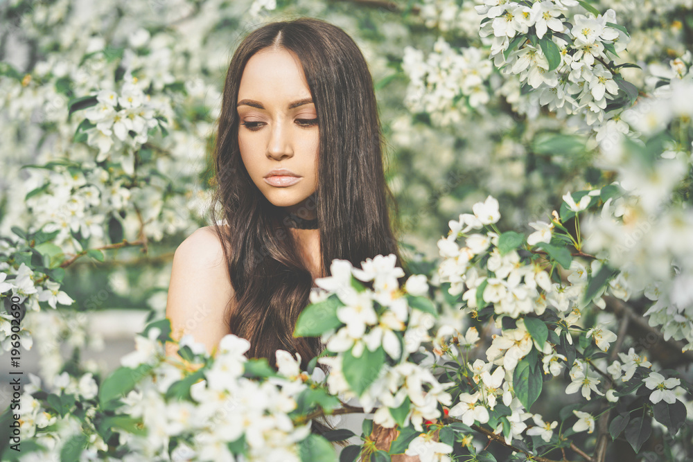 Beautiful young woman surrounded by flowers of apple-tree Beautiful young woman surrounded by flowers of apple-tree