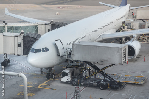Jet aircraft docked in international airport. special truck unloads cargo from the aircraft