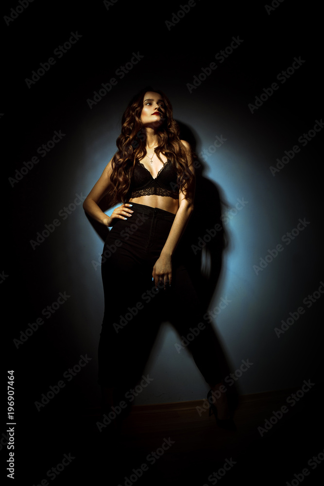 Gorgeous lady with curly hairstyle in dark studio Gorgeous lady with curly hairstyle in dark studio