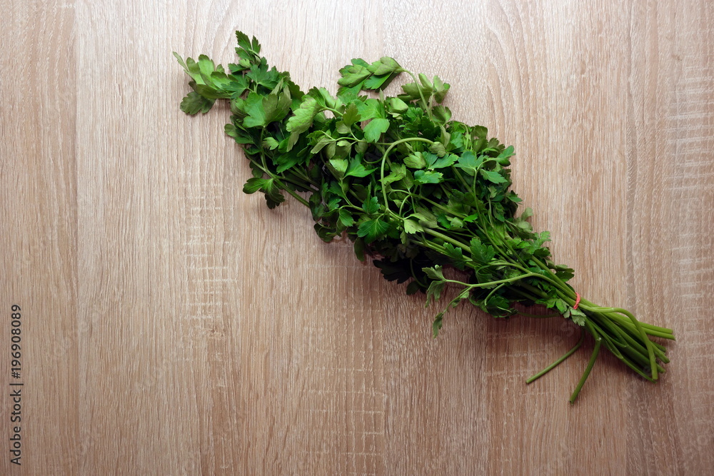 Bunch of green parsley leaves on rustic wooden background, copy space for your design Bunch of green parsley leaves on rustic wooden background, copy space for your design