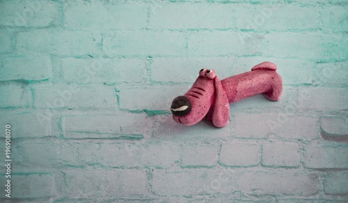 Pink toy dog on the blue pastel colored paper background. Flat lay. Minimal concept. © BEATA