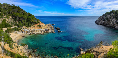 On the north coast of the island of Ibiza we find this beautiful cove of sand and rock. With piers for fishermen.