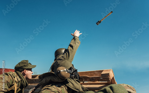 German soldier in uniform of the World War 2 period throwing a grenade , historical reenactment in Russia