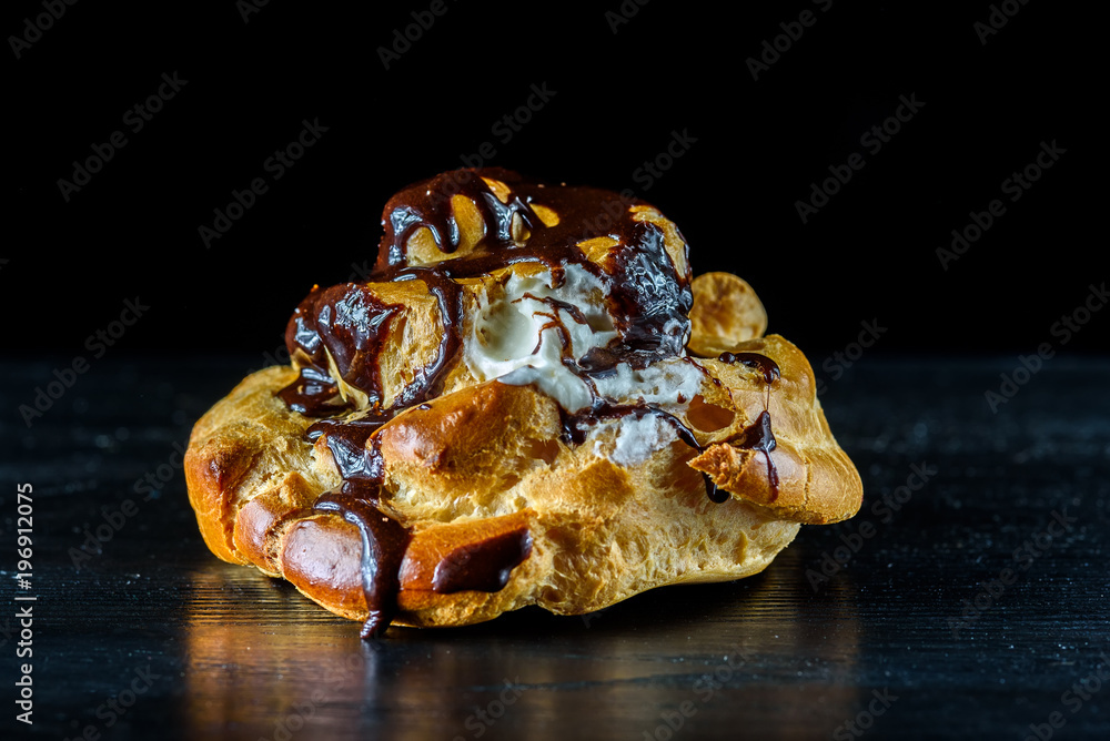 Eclair on a black wooden background Eclair on a black wooden background