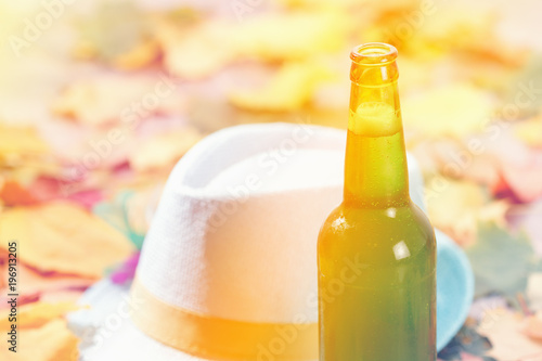 Bottle of Beer glass pint octoberfest picnic on natural background with hat and autumn leaves photo