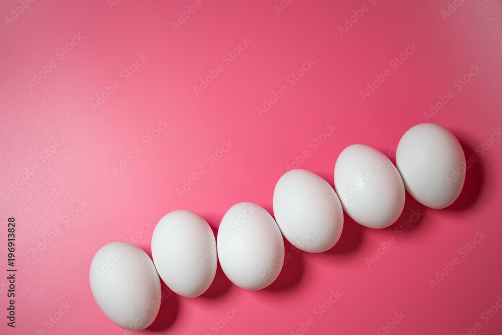 Minimal Easter concept. Top view. White eggs on pink background. Close up. Copy space. Flat lay.