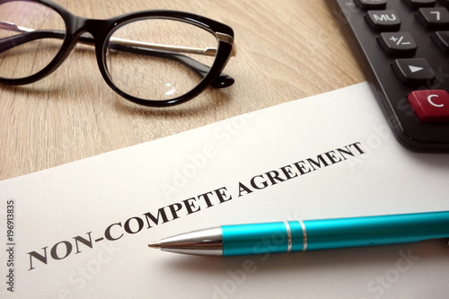 Non-compete agreement document for filling and signing on desk, business competition concept