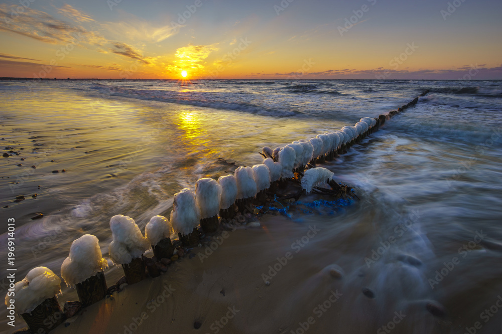 Fototapeta premium A beautiful sunset over the sandy beach on the Wolin Island in Poland in the winter