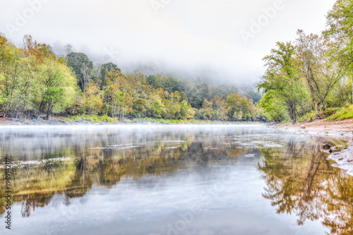 New River Gorge water river lake during autumn golden orange foliage in fall by Grandview with peaceful calm tranquil morning bright mist fog