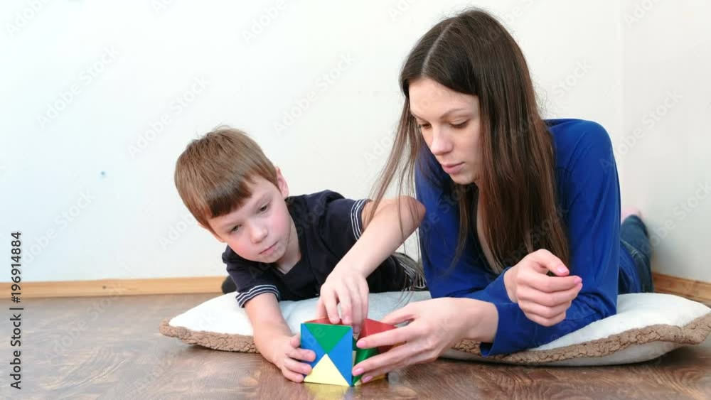 Mother and son are building from plastic constructor with non-ferrous magnetic triangles. Mother and son are building from plastic constructor with non-ferrous magnetic triangles.