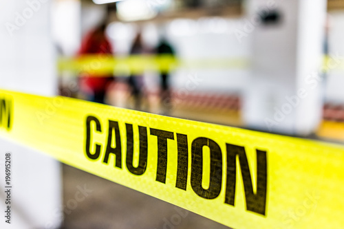Caution tape sign in underground transit empty large platform in New York City NYC Subway Station in Grand Central, ladder, wet floor cone