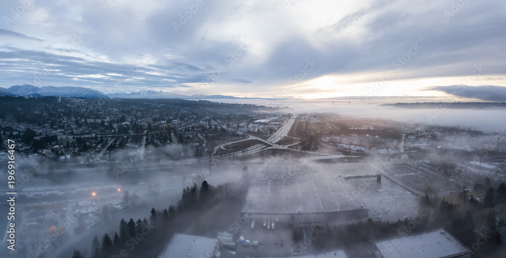 Aerial panoramic view of the residential neighborhood in the city during a foggy sunrise. Taken in New Westminster, Greater Vancouver, British Columbia, Canada.