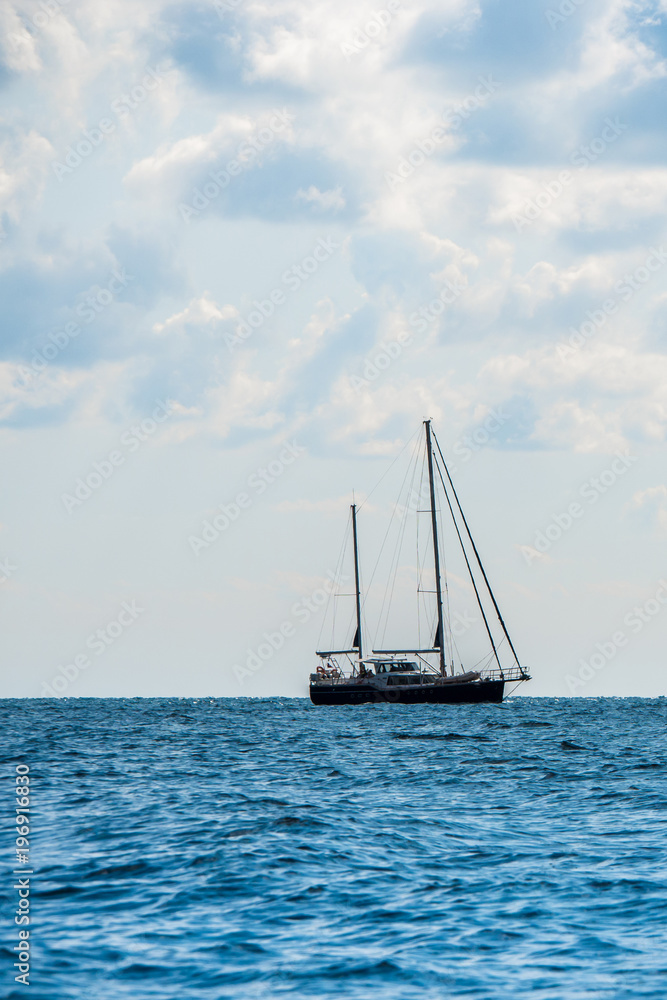 Sailing yacht in the open Sea. Blue water.