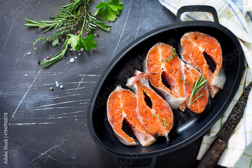 Fresh salmon pickled for a barbecue on a cast-iron frying pan. Copy space, top view flat lay background.